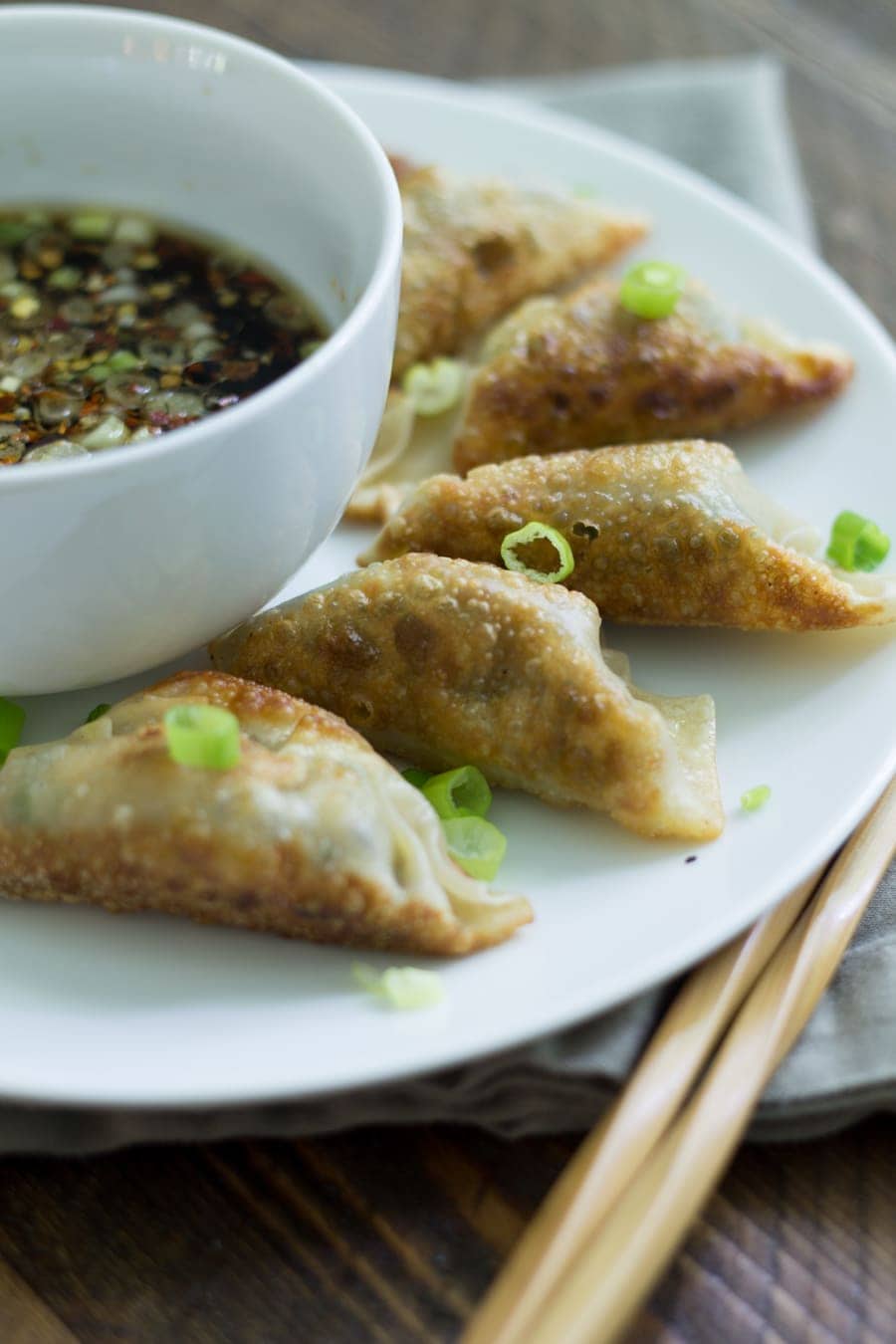 Plate of shiitake gyoza surrounding a bowl of dipping sauce 