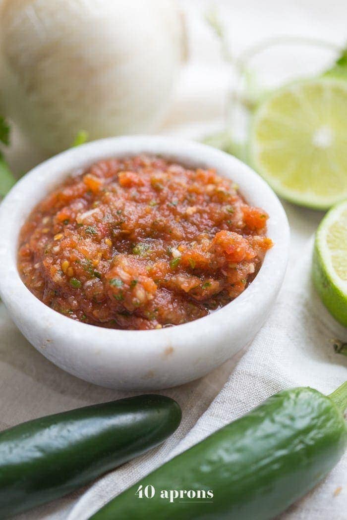 This is the best restaurant style salsa recipe, and I've been making it blissfully for almost a decade! What makes this the best restaurant-style salsa recipe? Spoiler alert: it comes from one of my favorite Mexican restaurants (but I'll never say which)! It blends fresh garlic, cilantro, chiles, onions, and tomatoes with canned tomatoes for the perfect blend of fresh and traditional restaurant style salsa. So good!