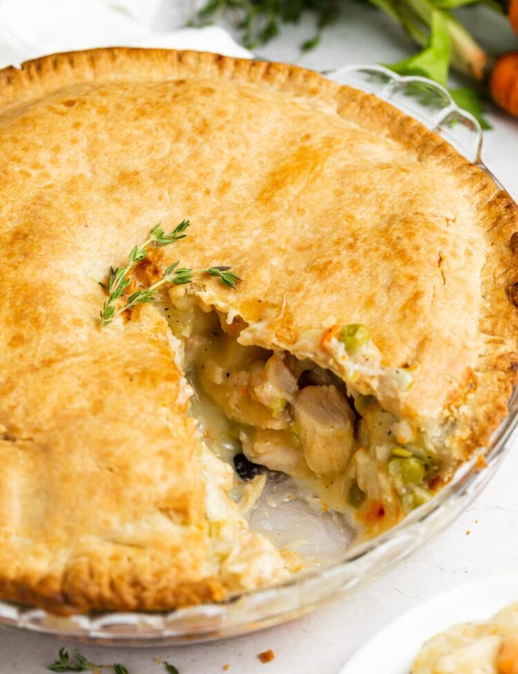 chicken pot pie with a slice removed and carrots on the side