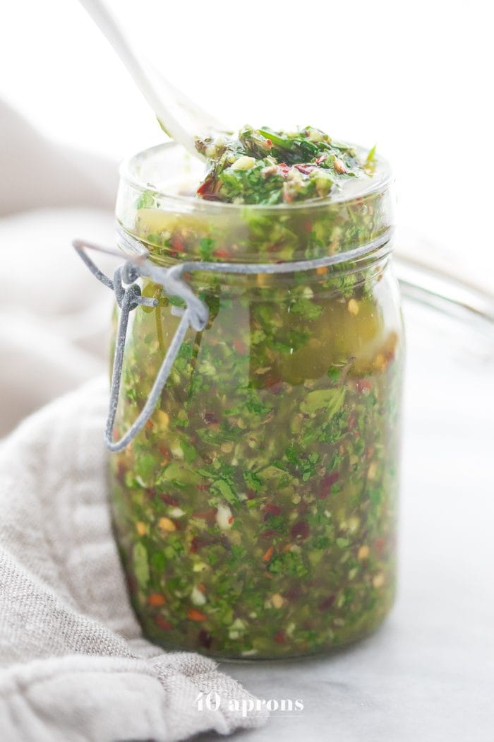 The best chimichurri recipe (Texas de Brazil chimichurri recipe) in a jar with a white spoon