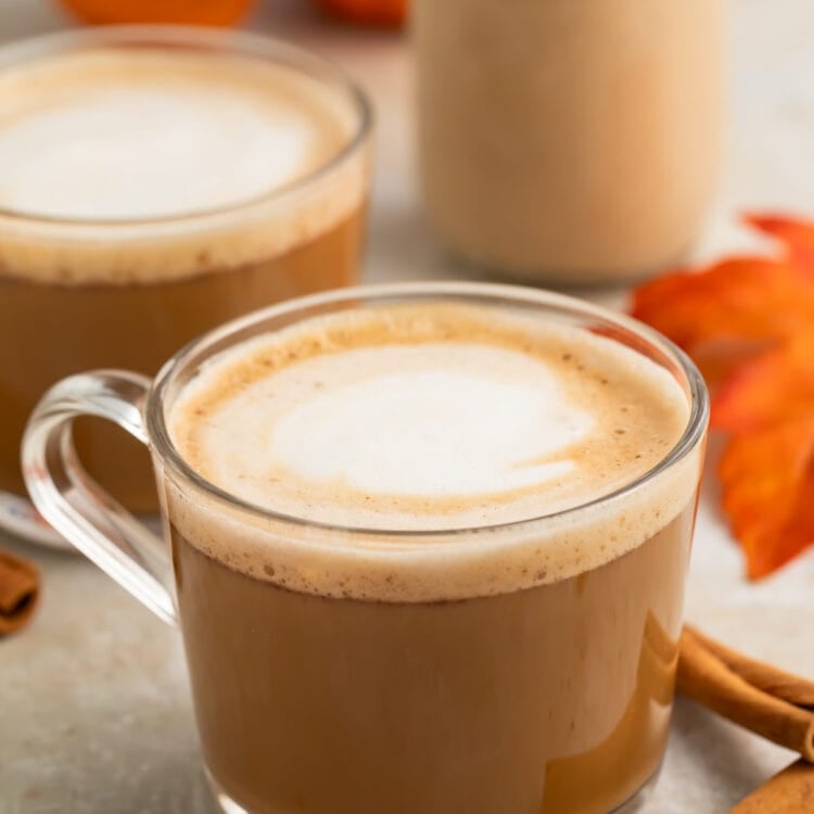 Two clear glass coffee mugs holding a pumpkin spice latte with rich pumpkin spice creamer.