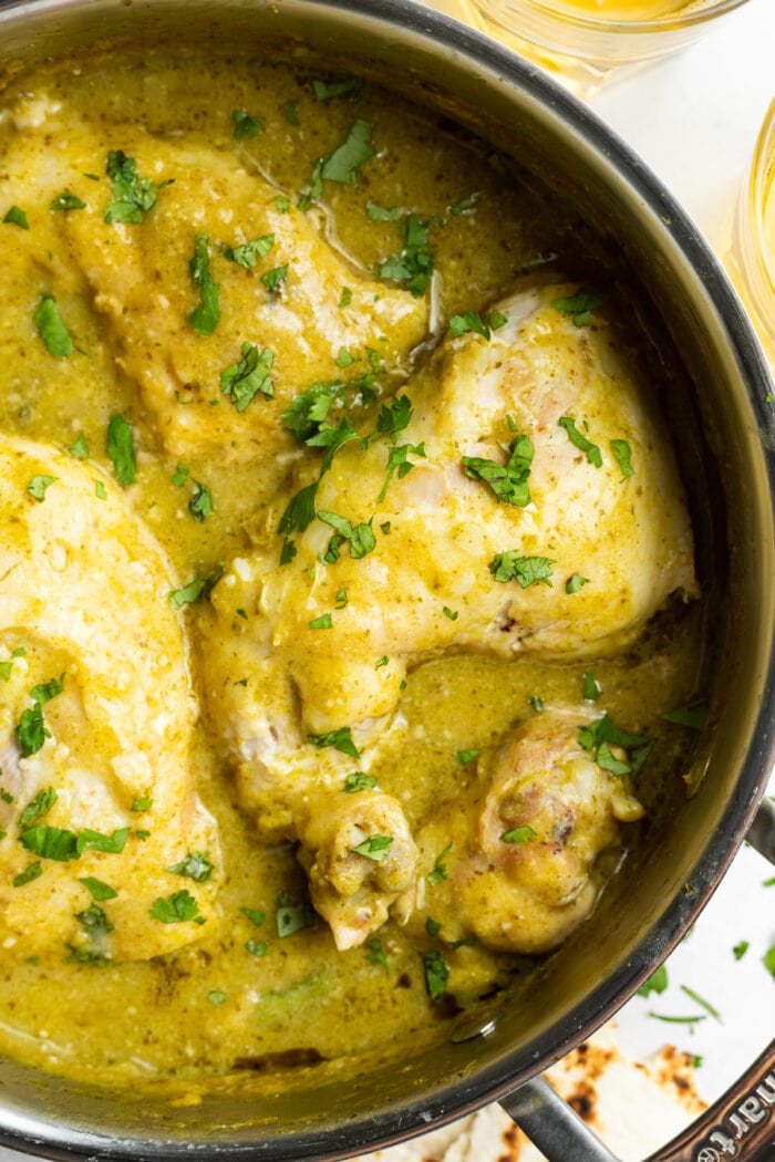 green mole chicken in a skillet with fresh cilantro on top