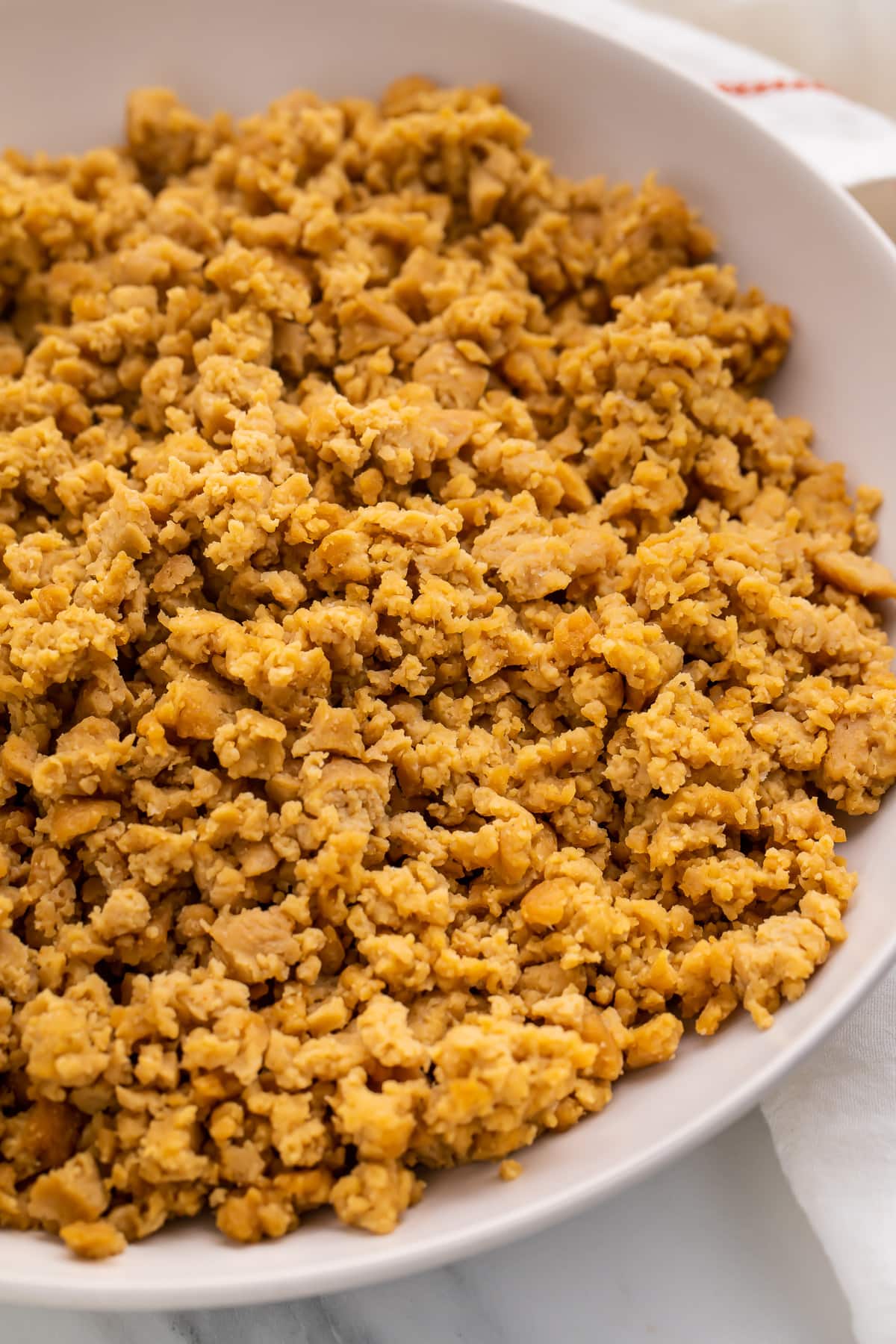 A bowl of crumbled ground beef made from seitan.