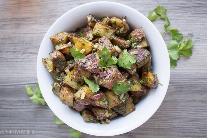 This herb roasted potato salad is absolutely delicious: crispy roasted potatoes, heady dried herbs, and a rich and creamy sauce with fresh herbs and minced red onions. Packed full of flavor, this herb roasted potato salad is destined to become a favorite, both with the family and with your guests! This herb roasted potato salad is also paleo, Whole30-compliant, and vegan friendly. Simply put, it's the best herb roasted potato salad out there.
