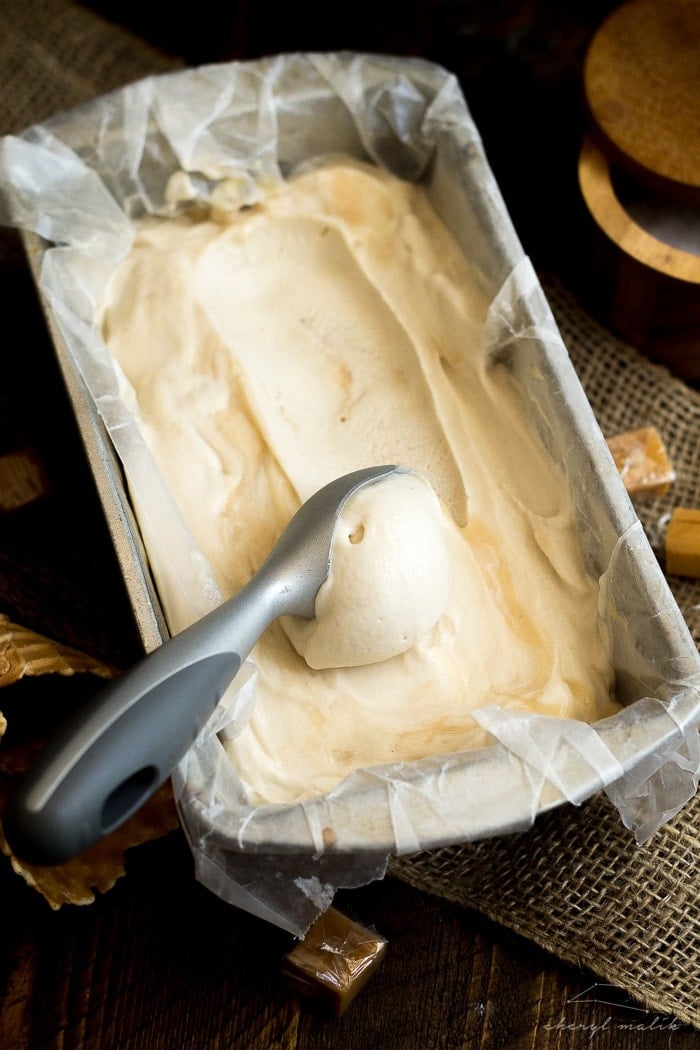 Salted caramel vegan ice cream in a loaf pan with an ice cream scoop