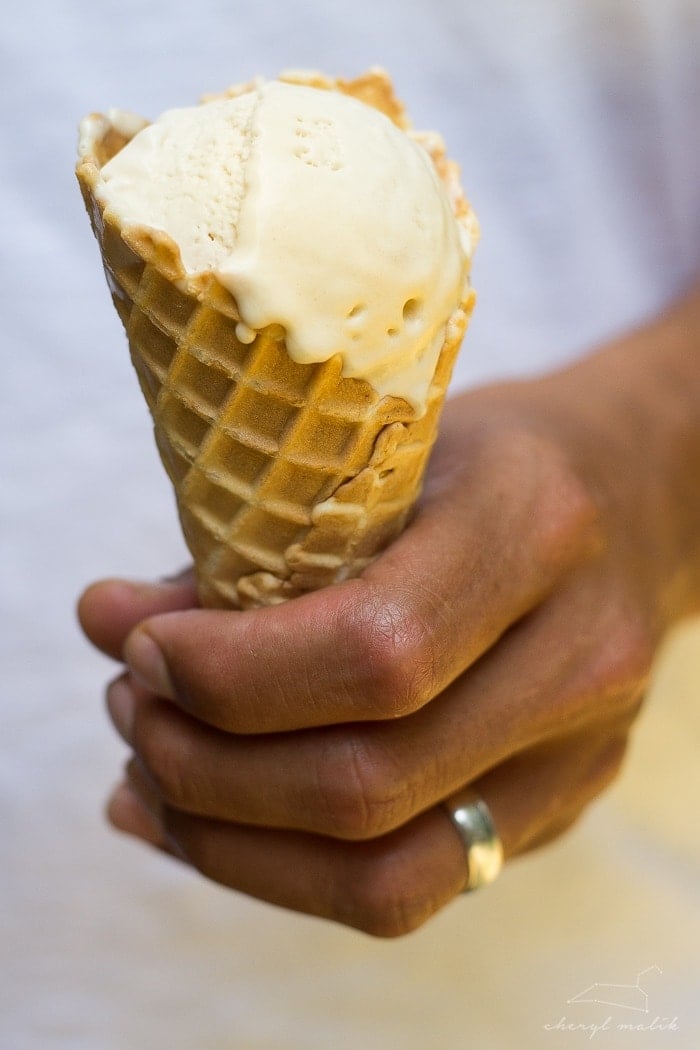 Salted caramel vegan ice cream in a loaf pan with an ice cream scoop