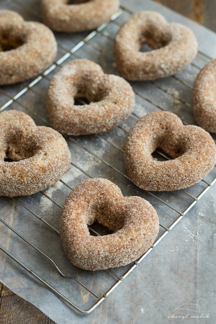 Baked apple cider donuts rolled in cinnamon sugar and topped with pomegranate glaze. Perfect for fall and so moist!