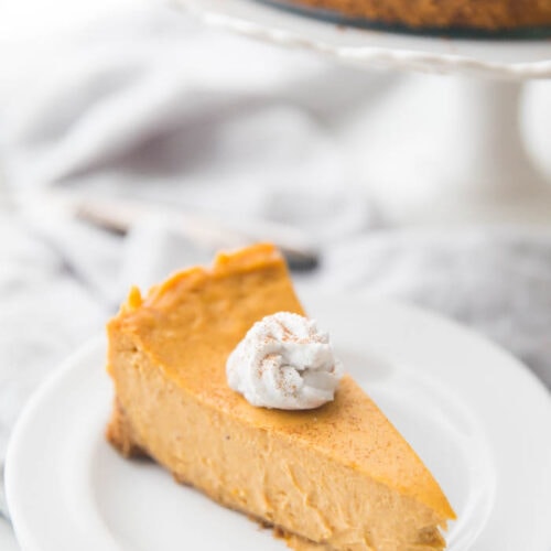 Vegan pumpkin cheesecake with whipped coconut cream on a plate