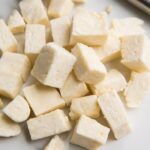 Cubes of paneer Indian cheese on a marble surface