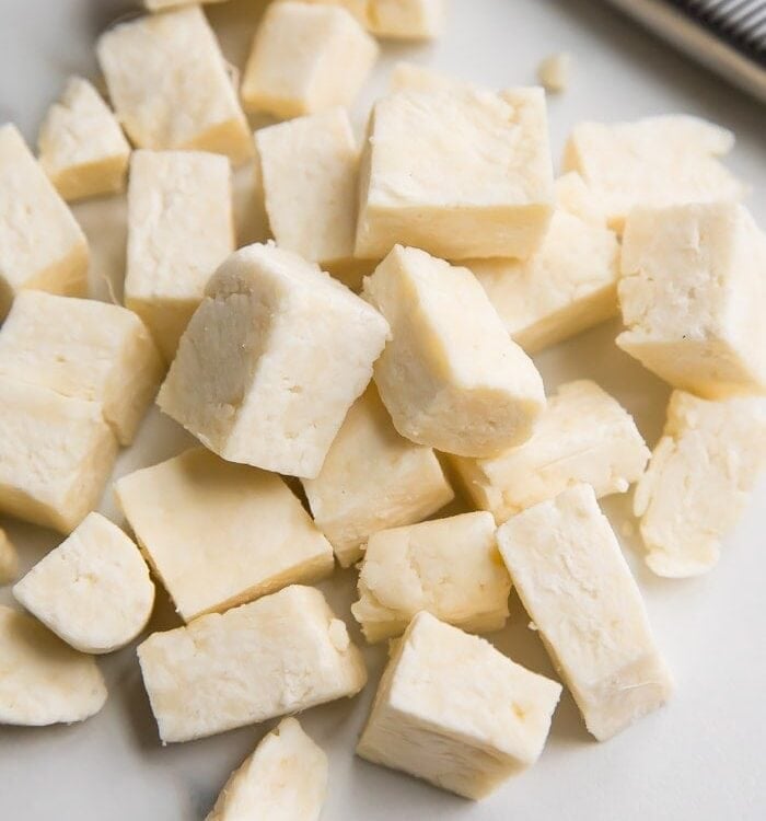 Cubes of paneer Indian cheese on a marble surface