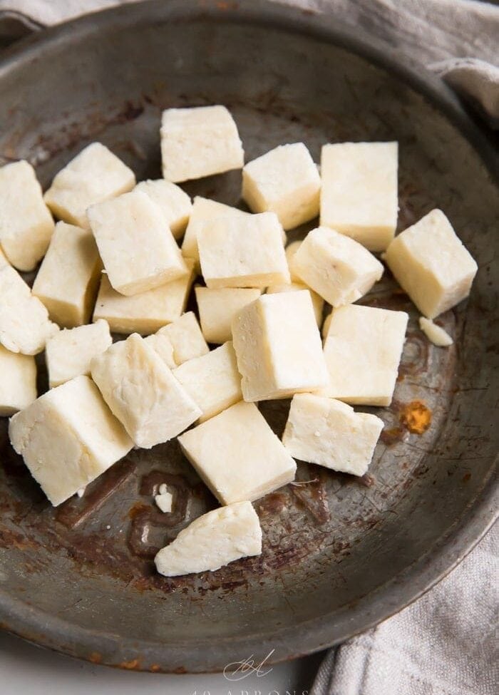 Cubes of paneer Indian cheese in a metal dish