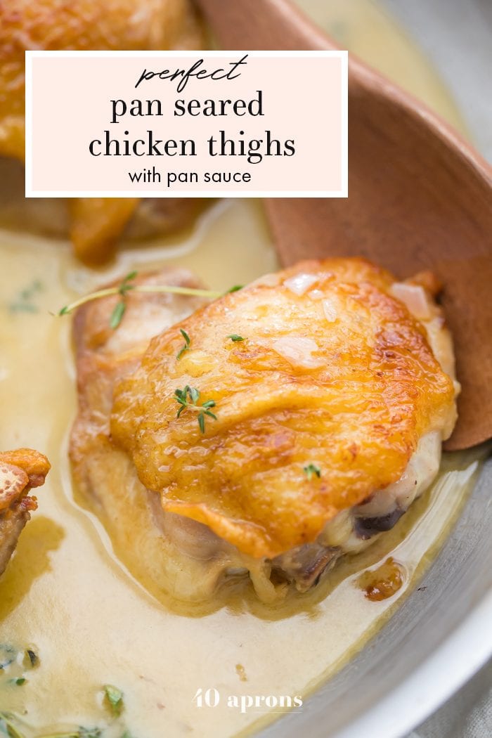 Perfect pan seared chicken thighs with pan sauce in a skillet with a wooden spoon