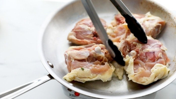 Place chicken thighs skin-side down in skillet.