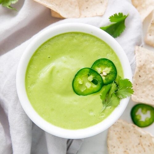 Avocado salsa in een witte kom met tortilla chips eromheen