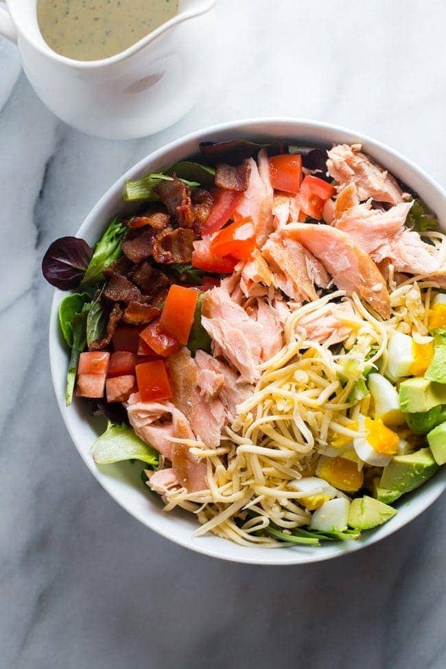 An absolute explosion of flavor, this smoked salmon cobb salad is layered with crisp bacon, creamy smoked gouda, cubed avocado, and tender boiled eggs.