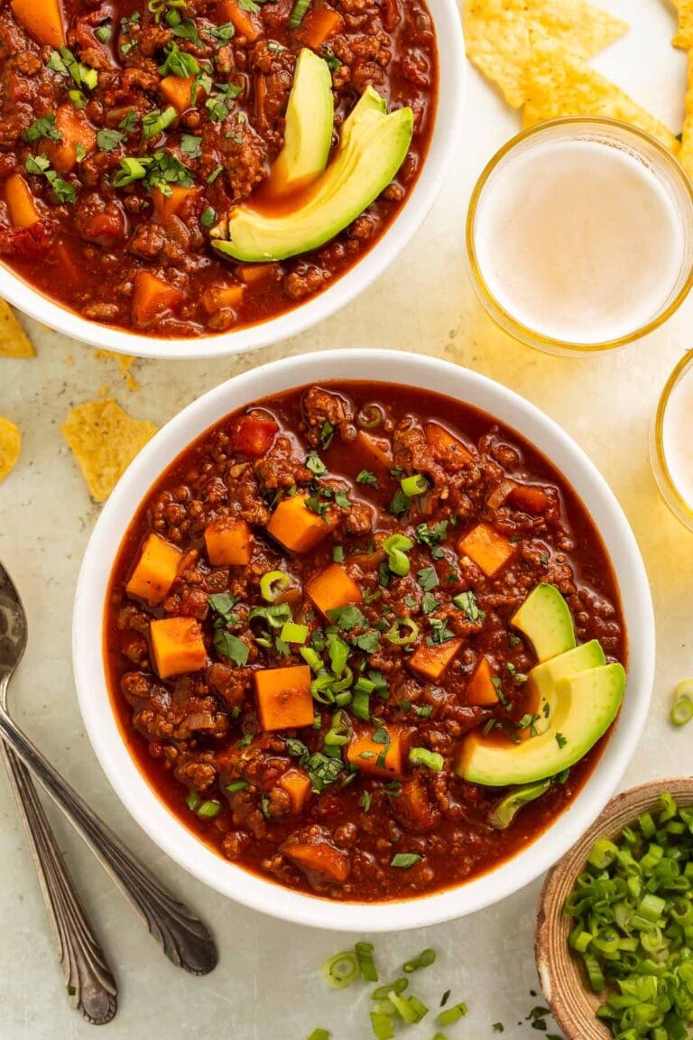 Two bowls of rich, deep red sweet potato chili on a table.