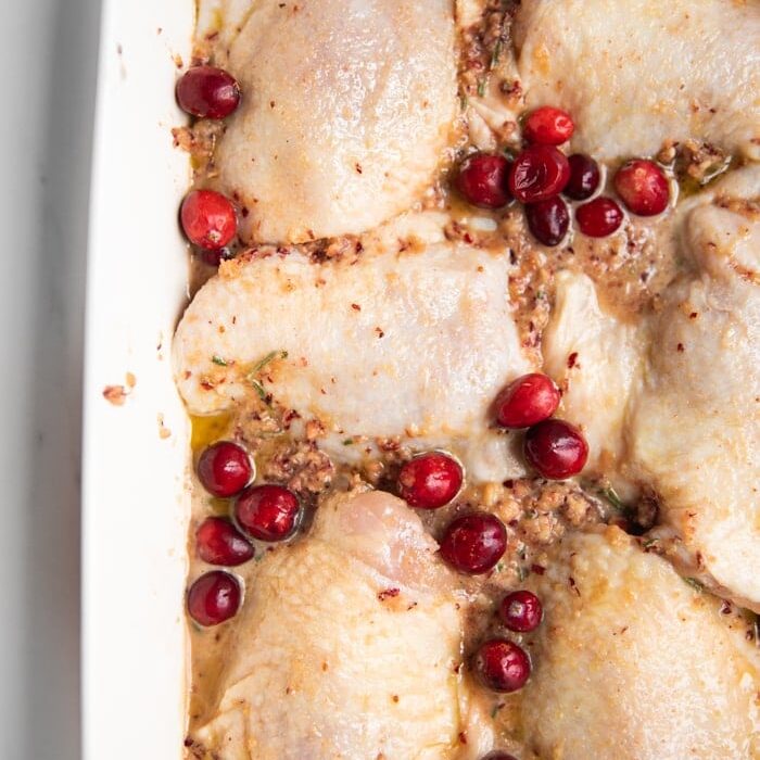 Scrape off marinade, brush with olive oil, season with salt, and sprinkle cranberries over