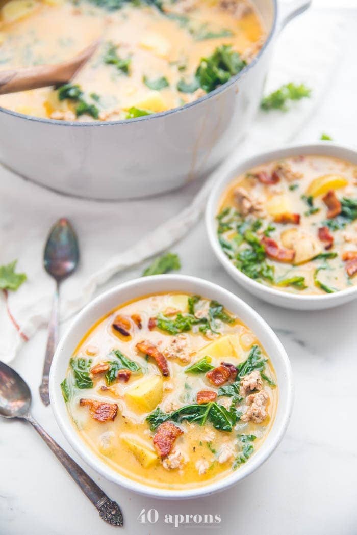Two bowls of Whole30 healthy zuppa toscana recipe with a pot in the background
