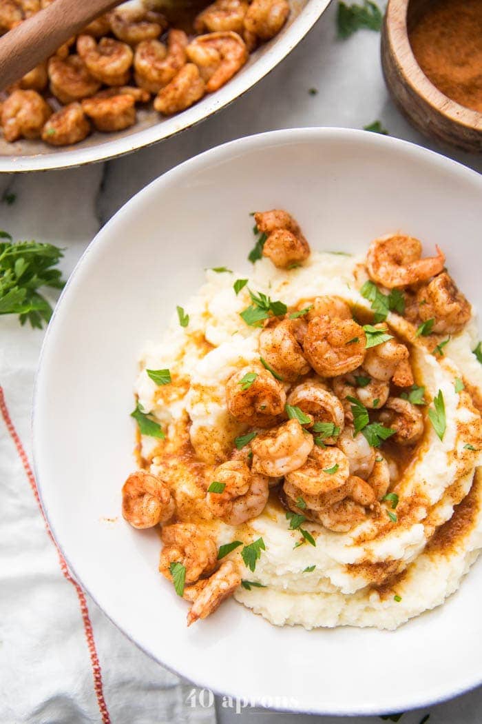 Whole30 healthy shrimp and grits in a bowl with skillet to the side