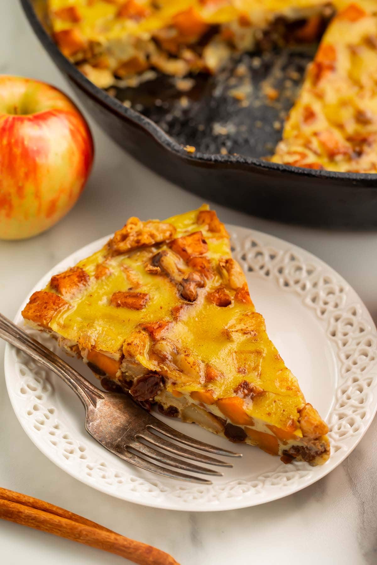 A triangular wedge of paleo breakfast bake on a small white plate with a fork.