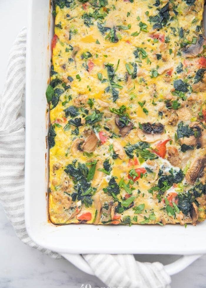 Whole30 breakfast casserole with sausage, spinach, and mushrooms in a baking dish