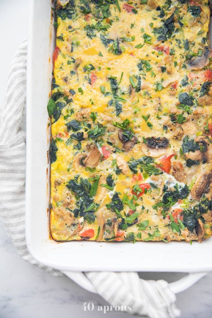 Whole30 breakfast casserole with sausage, spinach, and mushrooms in a baking dish