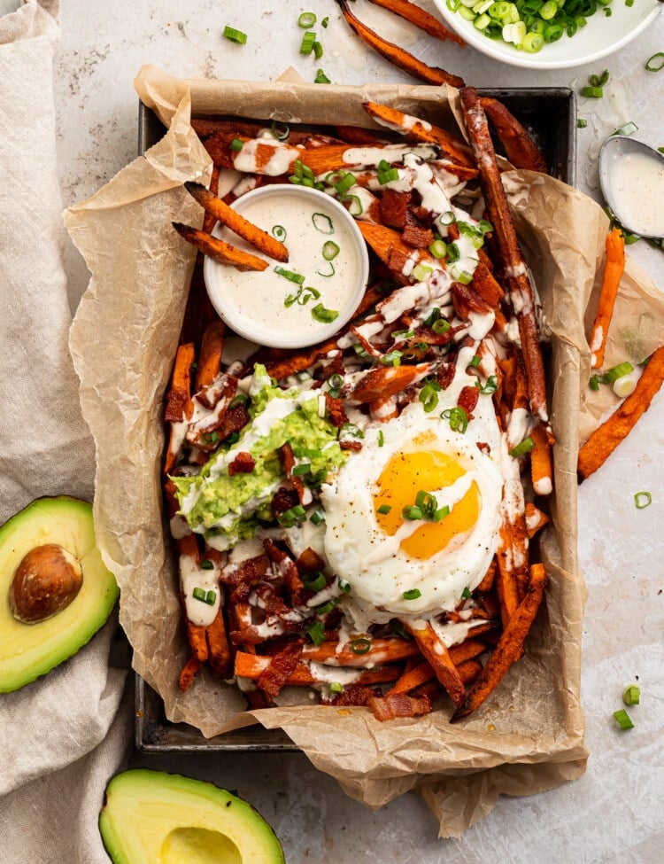 Whole30 Loaded Sweet Potato Fries in a parchment paper lined dish, shot from overhead