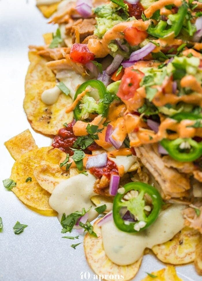 These paleo nachos are epic, aka the best paleo nachos ever. What makes paleo nachos epic, you ask? Well, what do you think of plantain chips topped with tender carnitas, the best paleo queso blanco, guacamole, pico de gallo, smoky guajillo salsa, and creamy chipotle sauce? If those doesn't sound like the best paleo nachos to you, I just don't even know who you are anymore.