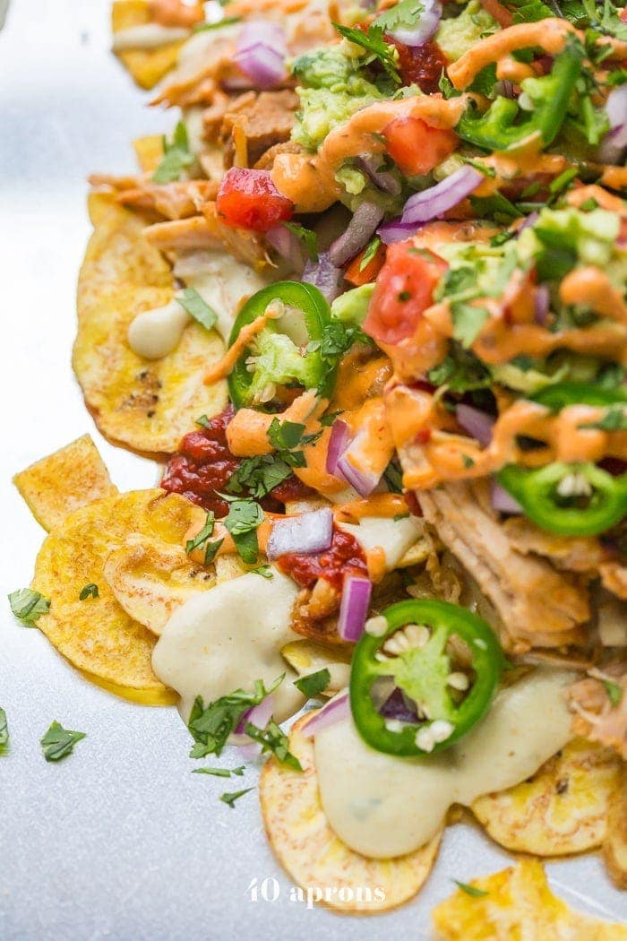 These paleo nachos are epic, aka the best paleo nachos ever. What makes paleo nachos epic, you ask? Well, what do you think of plantain chips topped with tender carnitas, the best paleo queso blanco, guacamole, pico de gallo, smoky guajillo salsa, and creamy chipotle sauce? If those doesn't sound like the best paleo nachos to you, I just don't even know who you are anymore. 