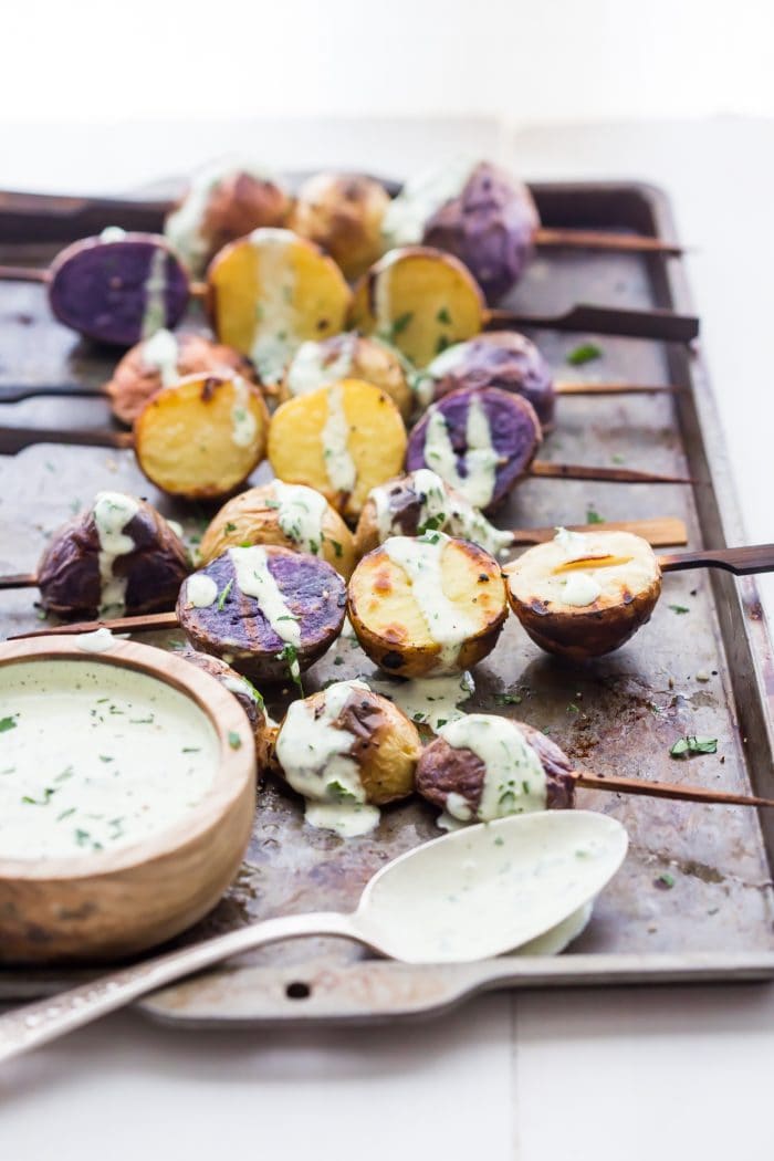 One of the best red, white, and blue side dishes! These grilled red, white, and blue potato skewers with ranch dressing are the perfect patriotic side dish. Garlicky, packed with flavor, and festive yet elegant, they go so well with burgers or brauts on the grill! One of the best red, white, and blue side dishes, these Whole30 potato skewers with ranch dressing are just delicious.