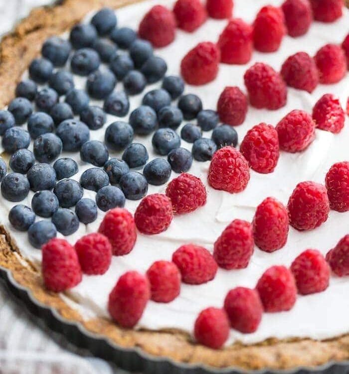 This paleo flag fruit tart is Fourth of July dessert perfection. With a coconut oil shortbread crust, rich almond fangiapane filling, and topped with cool coconut cream and fresh fruit, you've got your paleo Fourth of July dessert covered. Why make a paleo 4th of July cake when you can make a tart delicious enough to beat all other paleo 4th of July desserts?! U-S-A! U-S-A!