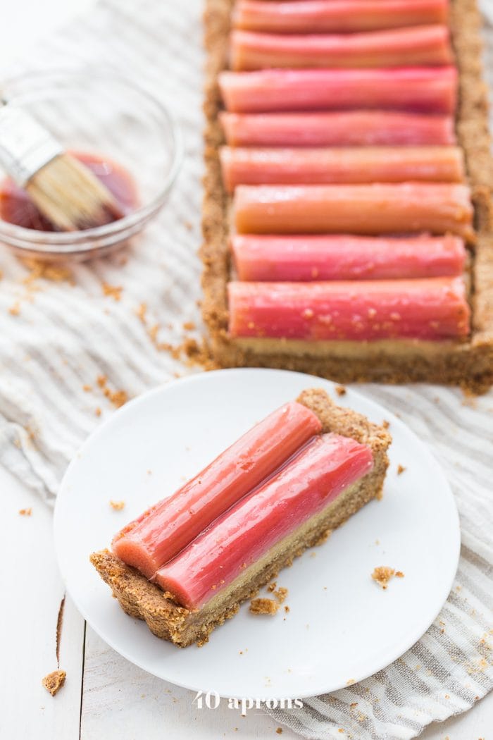 This paleo rhubarb tart is layered with a buttery shortbread crust, rich almond frangiapane filling, and finished with a perfectly sweet, tart rhubarb topping. This paleo rhubarb dessert is absolutely stunning and positively delicious, making it perfect for summer entertaining. This paleo rhubarb tart is a must-try!