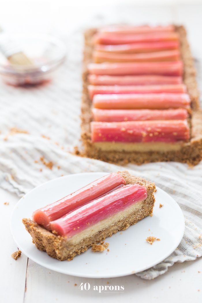 This paleo rhubarb tart is layered with a buttery shortbread crust, rich almond frangiapane filling, and finished with a perfectly sweet, tart rhubarb topping. This paleo rhubarb dessert is absolutely stunning and positively delicious, making it perfect for summer entertaining. This paleo rhubarb tart is a must-try!
