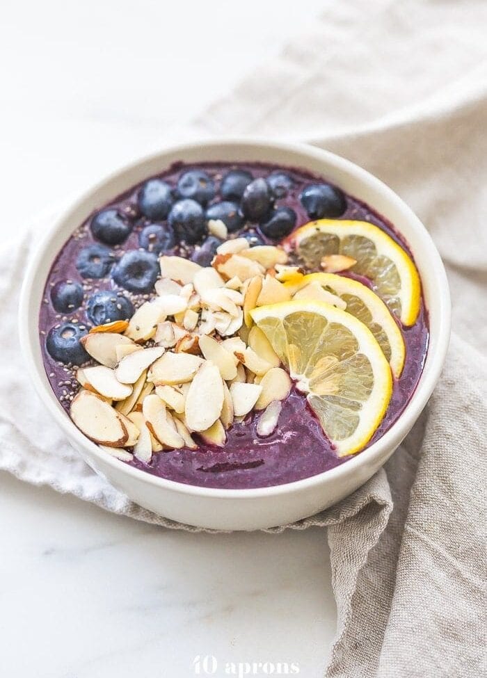 This blueberry muffin smoothie bowl is sweet with a touch of lemon and vanilla, just like a blueberry muffin! This blueberry smoothie bowl takes only 5 minutes and is paleo and vegan. With only 5 ingredients, you'll get addicted to this blueberry muffin smoothie bowl!