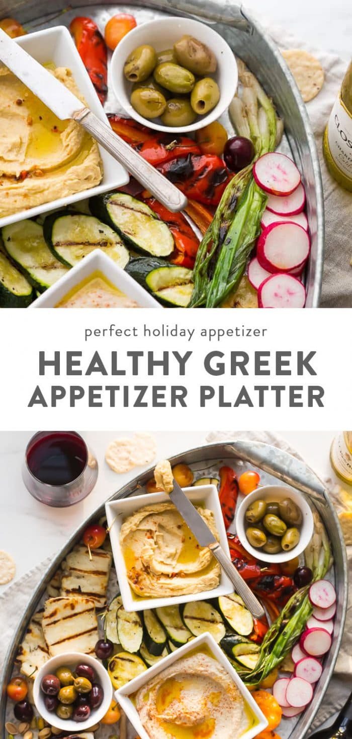 Healthy greek appetizers on a platter with wine on a table.