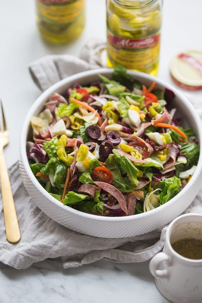 This paleo Italian salad is one of my very favorite paleo salads: loaded with radicchio, roasted garlic, olives, bright and spicy peperoncinis, salami, sun-dried tomatoes, and more. Such a great paleo dinner, paleo salad, or paleo side dish! Seriously, this paleo Italian salad will become a staple in your meal plan.