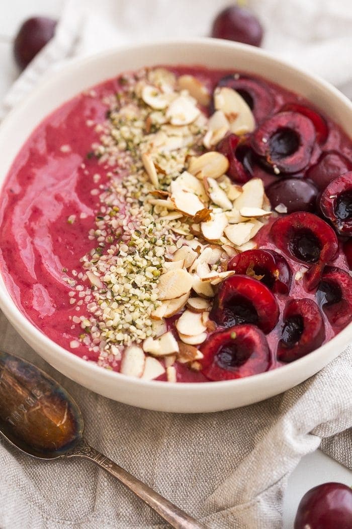This cherry smoothie bowl is so bright and refreshing yet totally filling. With only a handful of ingredients, this cherry smoothie bowl comes together in just a few minutes. This vegan smoothie bowl is perfect for the spring or summer and will keep you full for hours! Such a fantastic paleo smoothie bowl, too. It tastes so much like cherry pie: the vanilla extract really makes it!