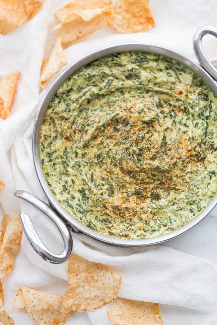 This paleo spinach artichoke dip is a healthy take on the classic appetizer. Rich and creamy, this vegan spinach artichoke dip is the perfect recipe for casual entertaining, especially in late summer and early fall. This paleo spinach artichoke dip is dairy free and goes perfectly with some paleo tortilla chips! One of my very favorite paleo appetizers, it really doesn't taste paleo!