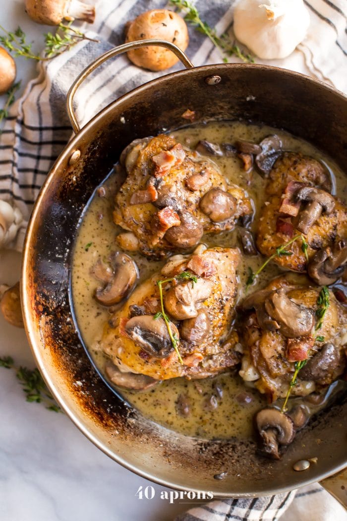 Bacon and mushroom chicken thighs in a pan