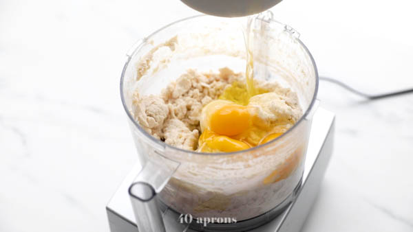 Combine flours, olive oil, salt, yeast mixture, and eggs in food processor