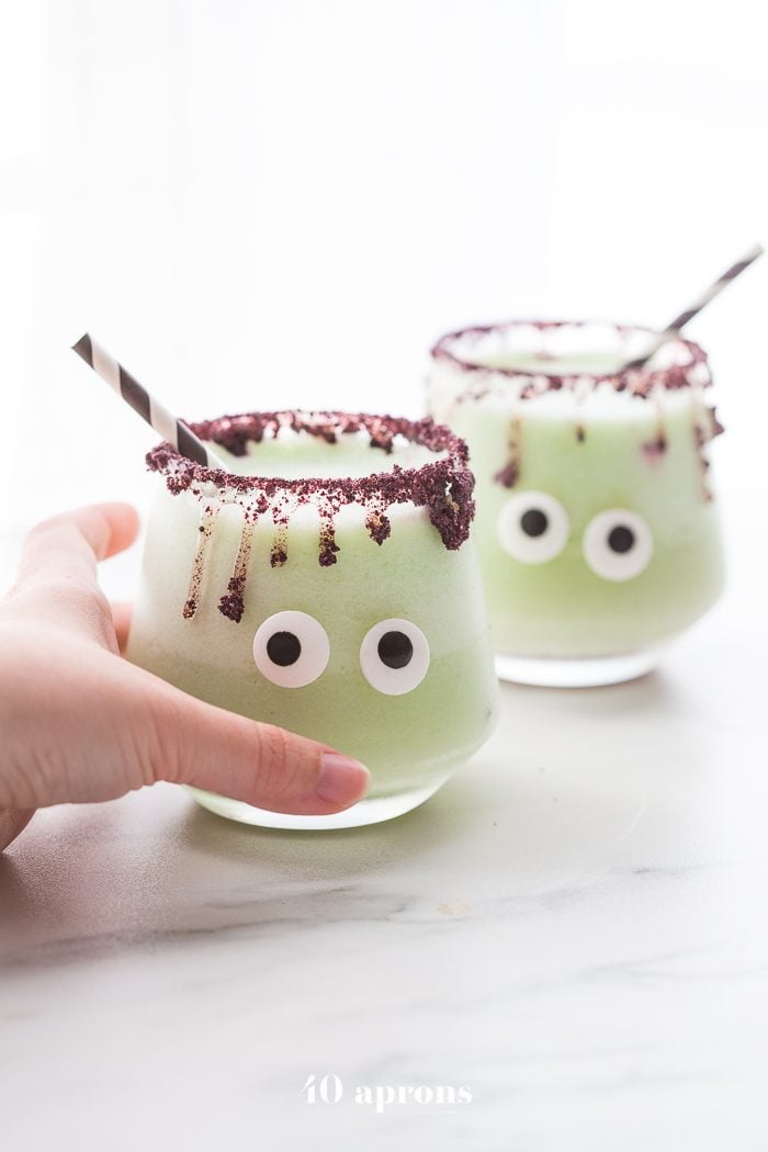 Monsteritas green Halloween cocktails with purple dripping rim and candy monster eyes in glasses