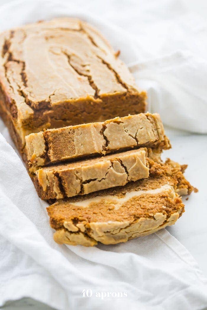 Paleo pumpkin bread with cream cheese swirl sliced on a white linen