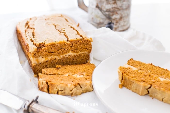 Paleo pumpkin bread with cream cheese swirl sliced with one piece on a plate