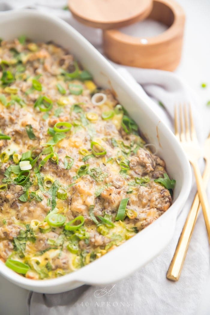 A baking dish of Whole30 hashbrown and sausage casserole with green onions on top