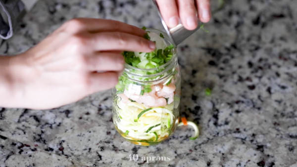 Layer zoodles, veggies, shrimp, egg, and scallions