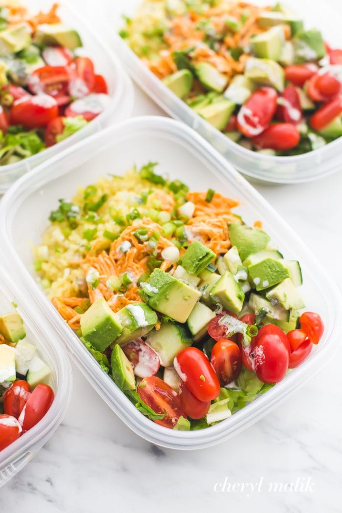 Buffalo chicken Whole30 meal prep recipe with avocado, cauliflower rice, and ranch dressing in container