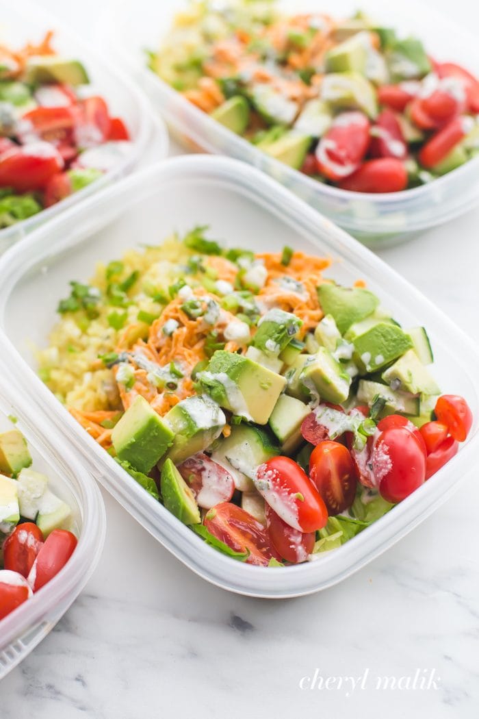 Buffalo chicken Whole30 meal prep recipe with avocado, cauliflower rice, and ranch dressing in container