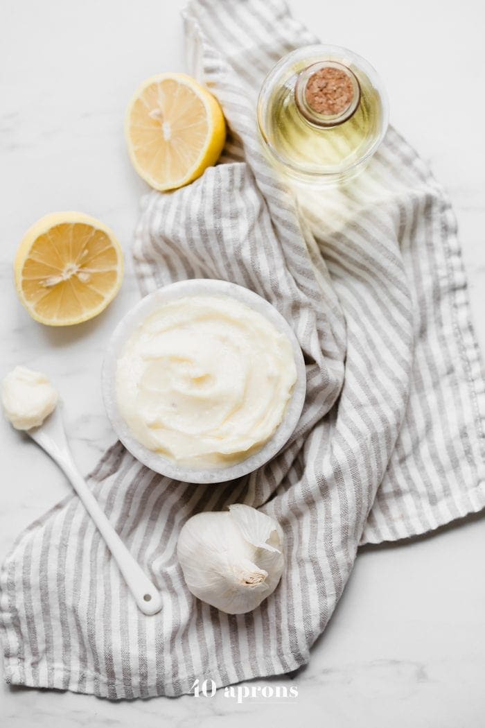 hole30 coconut oil mayonnaise in a bowl with lemons, garlic, and coconut oil