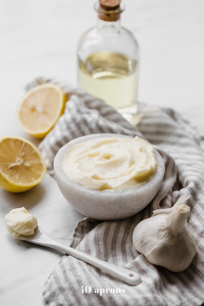 hole30 coconut oil mayonnaise in a bowl with lemons, garlic, and coconut oil