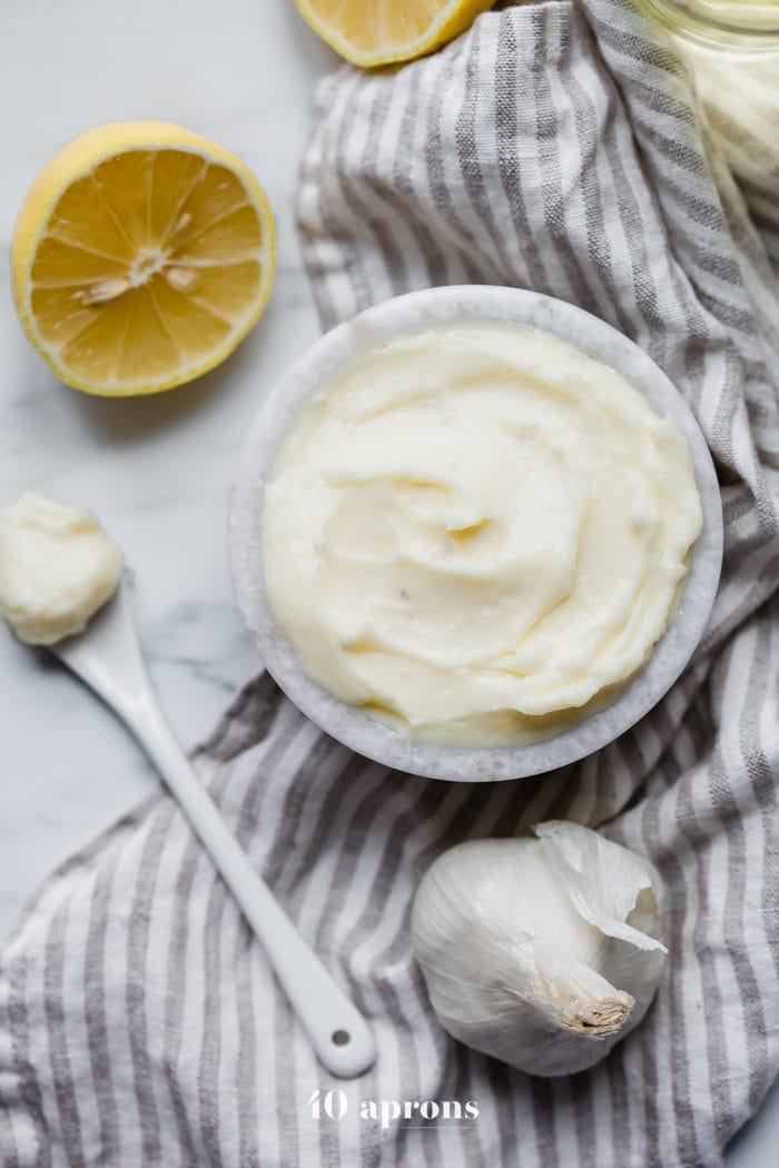 hole30 coconut oil mayonnaise in a bowl with lemons, garlic, and coconut oil